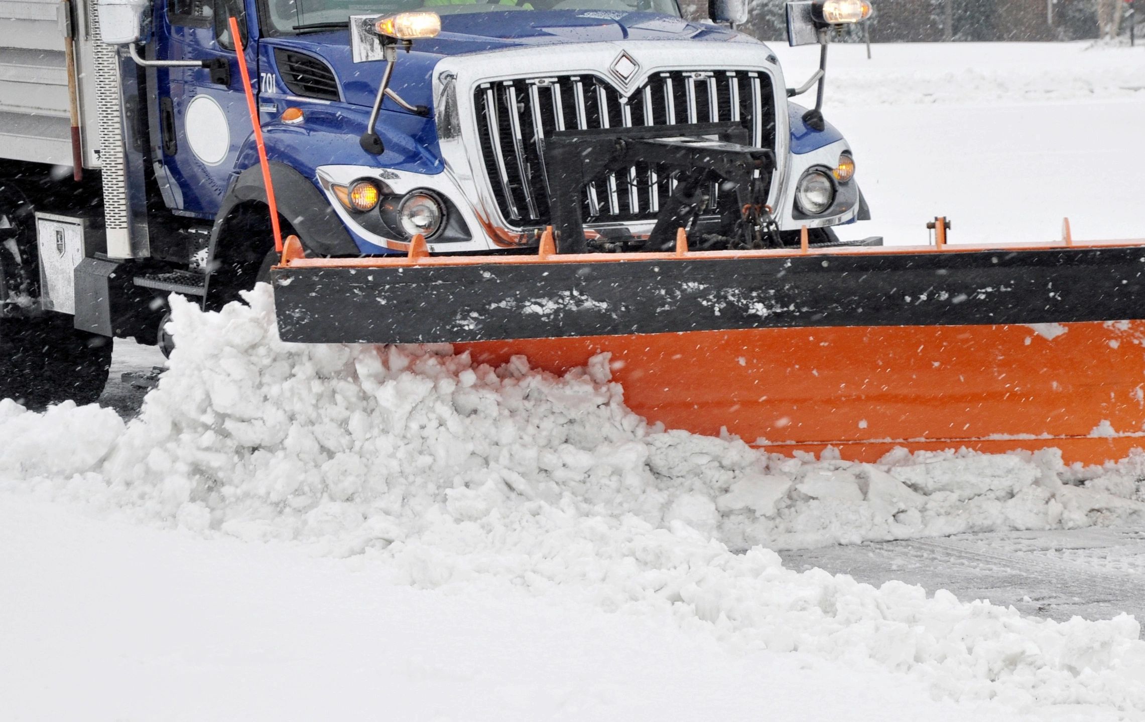 Snow plow truck clearing road in winter